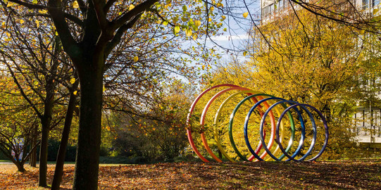 TU Dortmund University in autumn Steel spectral rings surrounded by trees in autumn.