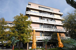 A building with plenty floors surrounded by trees.
